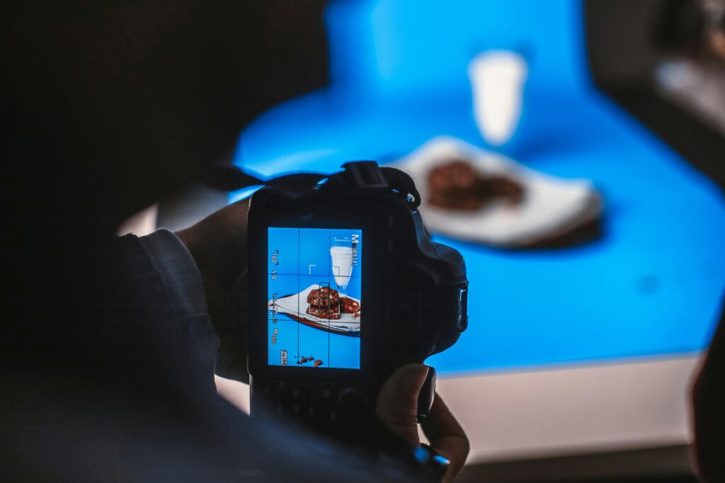pexels-photo-12811296-12811296 Close-up of a camera capturing a delicious dessert in a studio setting.